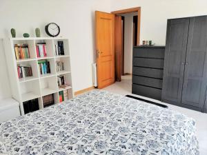 a bedroom with a bed and a book shelf at Bougainvillea Home - Ospedale Policlinico Monserrato in Monserrato