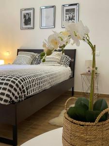 Un dormitorio con una cama y una cesta con flores en Rogier 6, en Mons