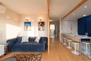 a living room with a blue couch and a kitchen at Porta do sol Luxury Apartment in Porto