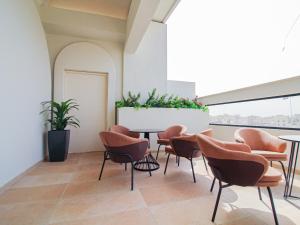 een wachtkamer met oranje stoelen en een tafel bij Friesian Hotel Suites in Jeddah