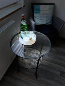 una botella de cerveza sentada en una mesa de cristal en Kleines Apartment in Siegburg-Kaldauen en Siegburg