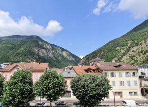 a group of buildings in front of a mountain at Terminus Hôtel des 3 Vallées in Moutiers