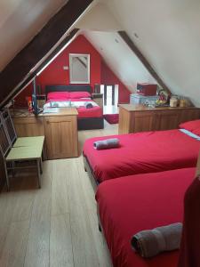 a attic bedroom with two beds and red walls at Pentre Riding Stables in Abercraf