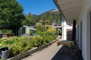 a porch of a house with a table and a garden at Fewo am Aubach-Josefine in Blaichach