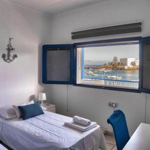 a bedroom with a bed and a large window at Casa Jolatero Ventana al Charco in Arrecife