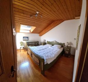 a bedroom with a bed and a wooden ceiling at Schlernwohnung in Seis am Schlern in Siusi