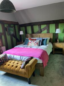 a bedroom with a large bed with a pink blanket at The Hole In The Wall in Little Wilbraham