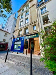 un edificio en una calle frente a una tienda en Hôtel Edgar & Achille en París