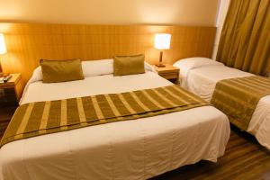 a hotel room with two beds and two lamps at Casablanca Center Hotel in Petrópolis