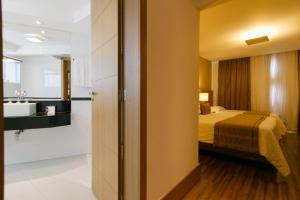 a hotel room with a bed and a sink at Casablanca Center Hotel in Petrópolis