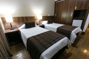 a hotel room with two beds and two lamps at Casablanca Center Hotel in Petrópolis