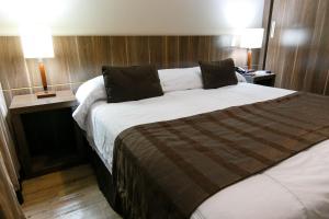 a large bed in a hotel room with two lamps at Casablanca Center Hotel in Petrópolis