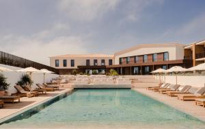 a hotel with a pool and chairs and a building at Aethos Hotel Ericeira in Ericeira +79 photos