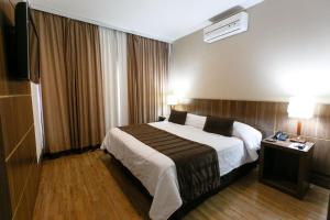 a hotel room with a bed and a television at Casablanca Center Hotel in Petrópolis
