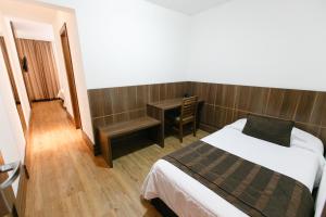 a hotel room with a bed and a desk at Casablanca Center Hotel in Petrópolis