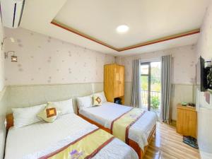ein Hotelzimmer mit 2 Betten und einem TV in der Unterkunft Khách sạn Triều Dâng in Liên Trì (4)