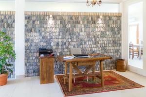 un ufficio con una scrivania in legno e un muro in pietra di Agriturismo la Chiocciola a Sacile