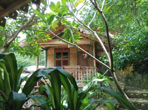 una casa en el bosque con un árbol en Lawang Inn en Bukit Lawang