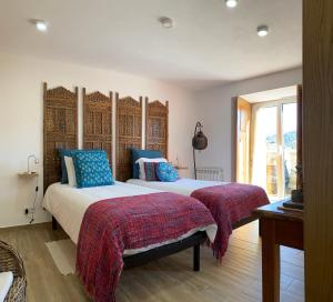 a bedroom with a large bed with blue pillows at Quinta Labruja in Labruja