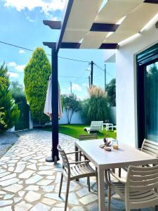 a patio with a table and chairs and an umbrella at Sunny Villa in Kissamos
