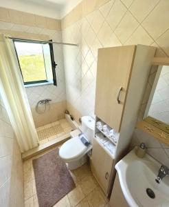 a small bathroom with a toilet and a sink at Sunny Villa in Kissamos