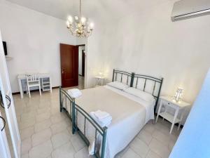 una camera con un grande letto e un lampadario a braccio di RomanoB&B a Bari