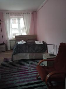 1 dormitorio con 1 cama con alfombra y ventana en Uroczy apartament, en Cracovia