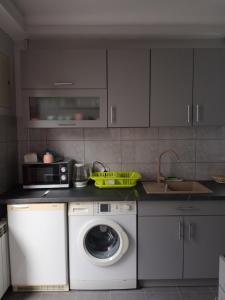 a kitchen with a washing machine and a microwave at Uroczy apartament in Kraków