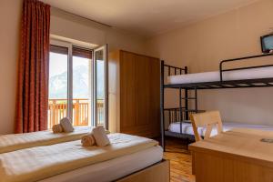 a bedroom with two bunk beds and a balcony at Hotel Lory - Molveno - Dolomiti in Molveno