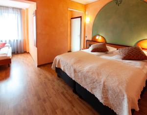 ein Schlafzimmer mit einem großen Bett in einem Zimmer in der Unterkunft Al Giardinetto in Biasca