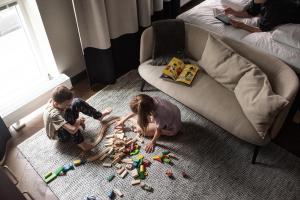 two children playing with toys on the floor next to a couch at Bob W Helsinki Katajanokka in Helsinki