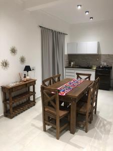 a dining room with a table and chairs and a kitchen at Wawa Estudio in Posadas