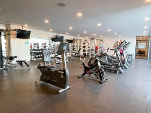 une salle de sport avec plusieurs tapis de course et machines cardio dans l'établissement Ipana by Andiani Travel, à Playa del Carmen