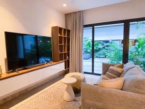 un salon avec une grande télévision à écran plat dans l'établissement Ipana by Andiani Travel, à Playa del Carmen