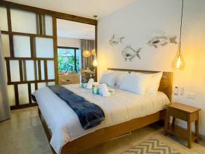 une chambre avec un grand lit avec des draps blancs dans l'établissement Ipana by Andiani Travel, à Playa del Carmen