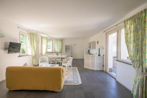 sala de estar con sofá amarillo y cocina en Gli Zerbi, en Gavi