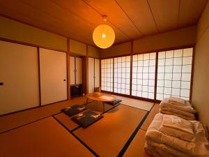 a room with a couch and a table and windows at 湯布院 星の里 Yufuin Hoshinosato in Yufuin
