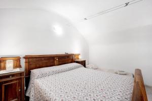 - une chambre avec un lit en bois et une commode dans l'établissement La casa tonda, à Dolceacqua