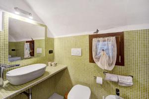 a bathroom with a sink and a toilet and a mirror at La casa tonda in Dolceacqua +15 photos