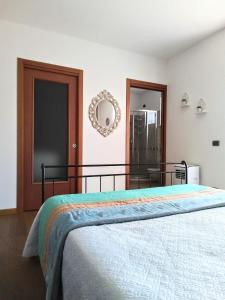 a bedroom with a bed and a mirror on the wall at Villa Bonetti in Costermano