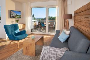 a living room with a blue couch and a chair at Landhaus Hoher in Oberteuringen