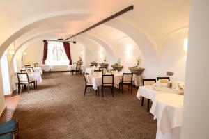 una sala da pranzo con tavoli e sedie bianchi di Hotel-Restaurant Liebnitzmühle a Raabs an der Thaya