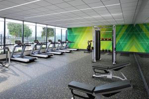 a gym with a row of treadmills and benches at Holiday Inn - Chicago - Tinley Park, an IHG Hotel in Tinley Park