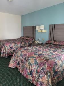 una habitación de hotel con 2 camas y una lámpara en Seneca Clipper Inn, en Watkins Glen