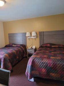 a hotel room with two beds and a phone at Seneca Clipper Inn in Watkins Glen