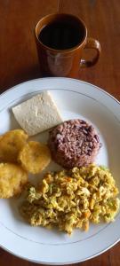 a plate of food with doughnuts and a cup of coffee at Finca Magdalena Eco Lodge in Balgue
