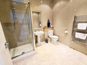 a bathroom with a shower and a toilet and a sink at Seas the Day Beachfront Apartment Ramsgate - Sleeps 4 in Ramsgate