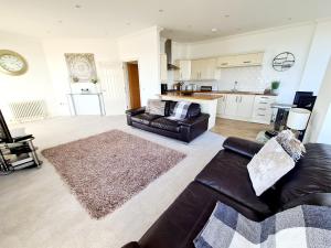 a living room with a couch and a kitchen at Seas the Day Beachfront Apartment Ramsgate - Sleeps 4 in Ramsgate