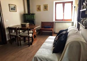 ein Wohnzimmer mit einem Tisch und einem Sofa in der Unterkunft Un Piccolo Rifugio in San Potito