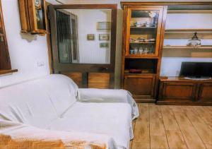 a living room with a white couch and a television at Un Piccolo Rifugio in San Potito